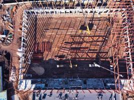 Construction site with metal frame and truck cranes from above. photo