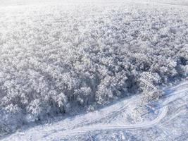 High-voltage power transmission tower in a frozen forest in winter. photo