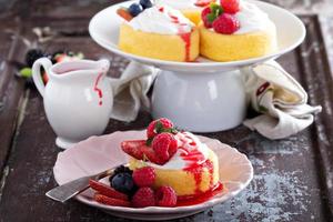 Pastry cups filled with cream and fresh berries photo