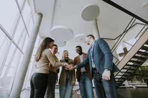 Group of positive businesspeople standing together in the office photo