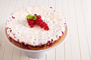 pastel de merengue de grosella roja sobre mesa blanca foto