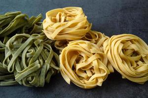 Fresh homemade green and yellow pasta tagliatelle. Raw homemade spinach pasta. photo