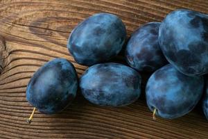 Ripe plums on a wooden table photo