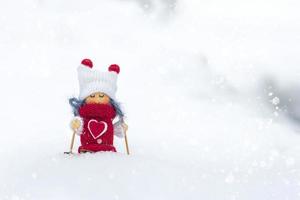 niña esquiadora juguete en bufanda y gorro de punto esquí elfo juguete en esquís en paisaje nevado año nuevo, feliz navidad tarjeta de felicitación invierno feliz año nuevo tarjeta hola diciembre, enero, febrero foto