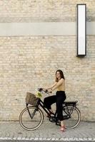 mujer con flores en la cesta de la bicicleta eléctrica foto