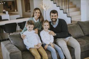 Happy family with two kids enjoy time together on couch in living room photo