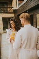 pareja joven relajándose en la terraza al aire libre y bebiendo jugo de naranja fresco foto