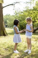 Cute asian and caucasian girl having fun in the park photo