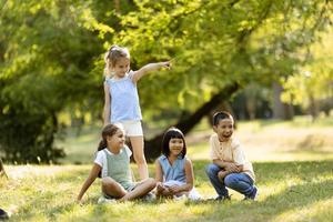 grupo de niños asiáticos y caucásicos divirtiéndose en el parque foto