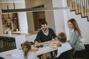 joven familia feliz hablando mientras desayuna en la mesa del comedor foto