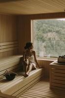 mujer joven relajándose en la sauna foto