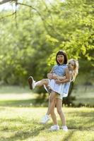 Cute asian and caucasian girl having fun in the park photo