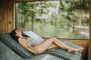 Young woman relaxing on the tepidarium bed in the spa photo