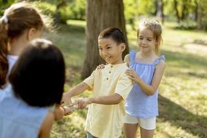 grupo de niños asiáticos y caucásicos divirtiéndose en el parque foto