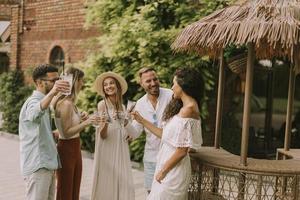 Group of young people cheering and having fun outdoors with drinks photo