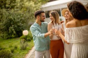 grupo de jóvenes felices animando con limonada fresca en el jardín foto