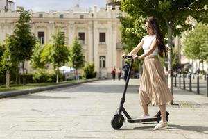 Young woman riding an electric scooter on a street photo