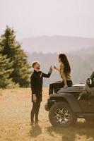 Young couple relaxing on a terrain vehicle hood at countryside photo