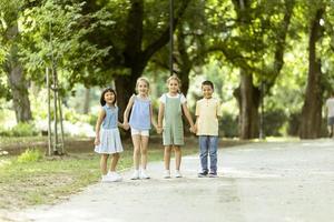 grupo de niños asiáticos y caucásicos divirtiéndose en el parque foto