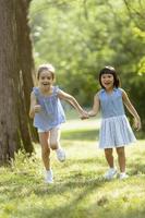 niña caucásica y asiática corriendo en el parque foto