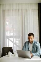 Young man using laptop and drink tea in the living room photo