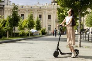 Young woman riding an electric scooter on a street photo