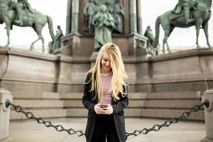 Young woman with mobile phone on the street of Vienna, Austria photo