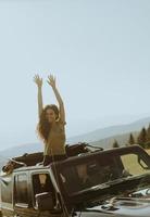 Young woman enjoying freedom in terrain vehicle on a sunny day photo