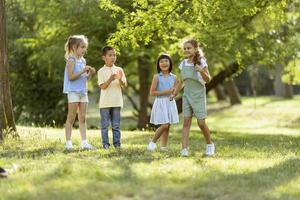 grupo de niños asiáticos y caucásicos divirtiéndose en el parque foto