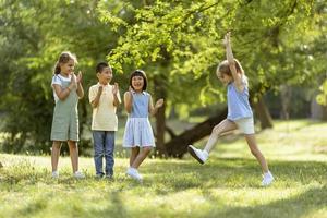 grupo de niños asiáticos y caucásicos divirtiéndose en el parque foto