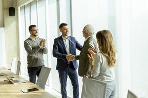 Business partners handshaking after making agreement with employees near by photo