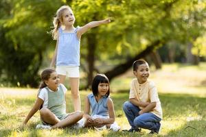 grupo de niños asiáticos y caucásicos divirtiéndose en el parque foto