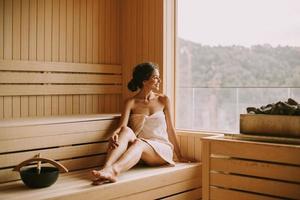 mujer joven relajándose en la sauna foto