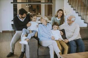 familia multigeneracional sentada en el sofá de casa y viendo la televisión foto