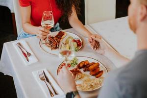 Young couple having lunch with white wine in the restaurant photo