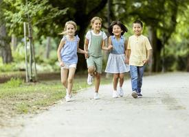 grupo de niños asiáticos y caucásicos divirtiéndose en el parque foto