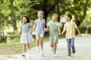 grupo de niños asiáticos y caucásicos divirtiéndose en el parque foto