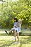 Cute asian and caucasian girl having fun in the park photo