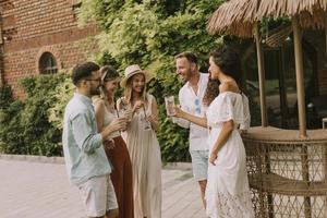Group of young people cheering and having fun outdoors with drinks photo