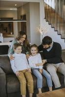 Happy family with two kids enjoy time together on couch in living room photo