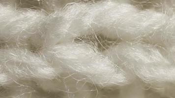 boucle parfaite de texture de tricot de laine blanche. horizontal le long des rangées détaillées de crochet de tissage. fond textile chandail. gros plan macro. video