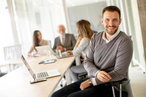 joven hombre de negocios que trabaja con sus compañeros de equipo en la oficina foto