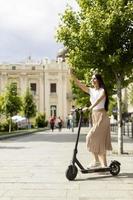 Young woman riding an electric scooter on a street photo