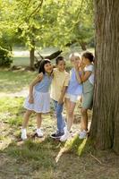 grupo de niños asiáticos y caucásicos divirtiéndose en el parque foto