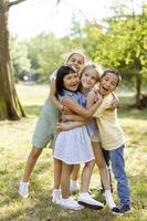 grupo de niños asiáticos y caucásicos divirtiéndose en el parque foto