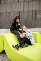 Young women sitting in the city and use a mobile phone photo