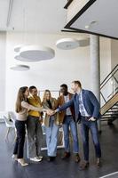 Group of positive businesspeople standing together in the office photo