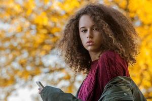 Teen girl in autumn park photo