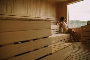 mujer joven relajándose en la sauna foto