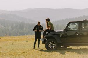 Young couple relaxing on a terrain vehicle hood at countryside photo